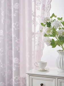 Detail of light pink French lace curtain with 3D rose patterns and scalloped edges