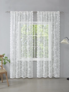 Close-up of white lace curtain featuring delicate floral rose embroidery and scalloped edges