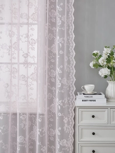 Detail of light pink floral lace curtain with rose patterns and wavy scalloped edges
