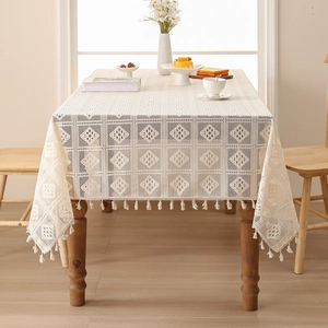 Detail of hollowed-out lace tablecloth with geometric patterns and tassel fringe edge
