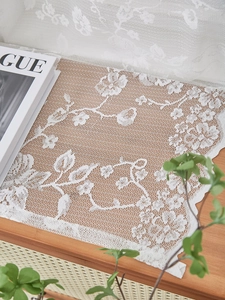 Close-up of white French vintage lace fabric with intricate floral patterns and embroidery