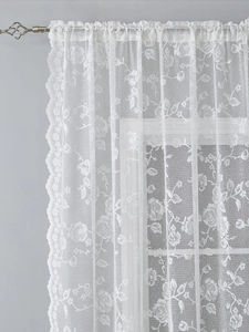 Detailed close-up of white lace curtain with elegant rose floral hollow design and wavy edges