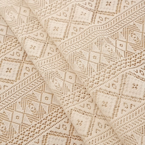 Detailed macro shot of beige bohemian lace tablecloth with geometric hollow patterns