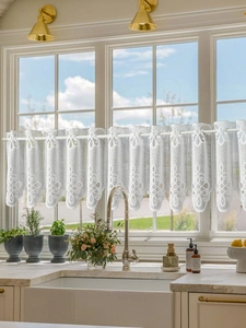 Detailed embroidery on white lace cafe curtain showing floral and wavy patterns