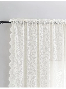 Dettaglio ravvicinato della tenda in pizzo bianco vintage francese con bordi ricamati