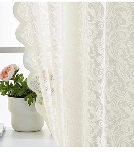 Dettaglio della tenda in pizzo bianco con motivo damascato e bordi a forma di onda