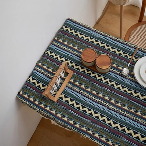 Macro detail of Bohemian geometric table runner with decorative cream cotton tassels
