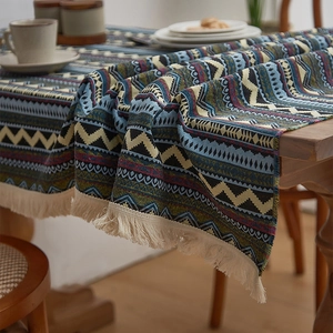 Detail of bohemian woven tablecloth showing colorful geometric patterns and cotton tassels