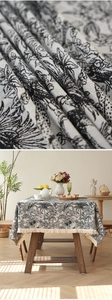 Macro shot of jacquard tablecloth with black jungle prints and beige fringe detail