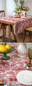 Detail of red Toile de Jouy jacquard tablecloth with fringe and tropical motifs