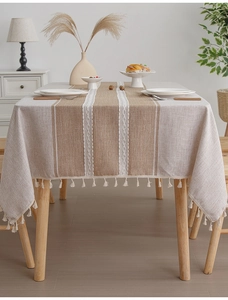 Close-up of linen woven tablecloth with white tassels and elegant striped pattern