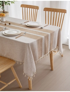 Detail of luxury linen tablecloth with brown stripes and decorative tassel edges