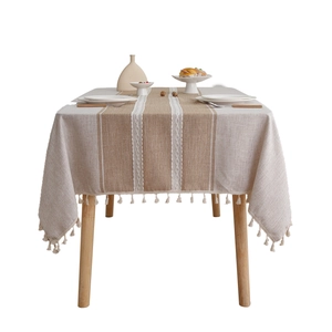 Linen blend tablecloth with brown stripes, white lace trim and tassels on a wooden table