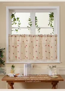 Detailed view of cherry embroidery and tassel edge on linen cafe curtain fabric