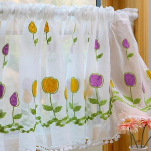 Country style sheer lace cafe curtain with tulip embroidery and pompom trim on wooden window