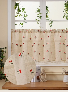 Detail of linen cafe curtain featuring cherry embroidery and tassel fringe edges