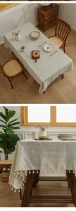 Detailed view of beige linen tablecloth with rustic texture and decorative tassel edges