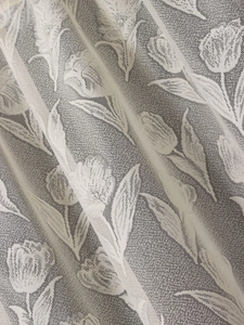 Detailed macro view of off-white tulip lace fabric texture for curtains and decor
