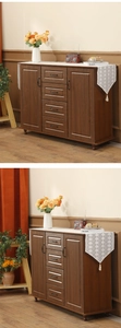 Detail of walnut storage cabinet showing symmetric four-drawer design and black metal handles