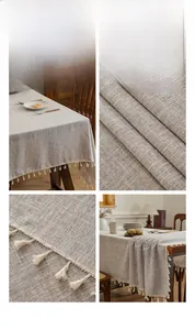 Detail of natural linen tablecloth featuring delicate cream white tassels and fine stitching