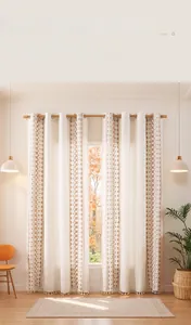 Detail view of linen curtains with geometric embroidery and tassels in a cozy room