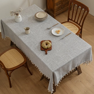 Thick linen tablecloth in light grey with elegant white tassels for dining tables