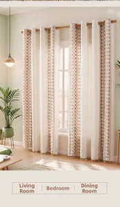 Detail of linen curtains with brown geometric embroidery and bottom tassel fringe accents