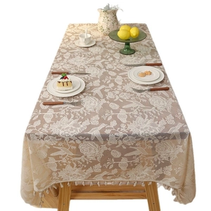 Bohemian lace tablecloth with floral patterns and elegant tassels on a wooden dining table