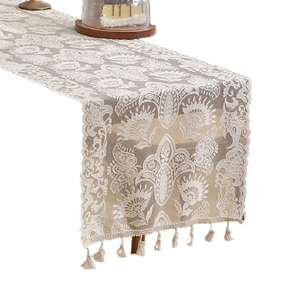Vintage white lace table runner with intricate floral patterns and elegant fringe tassels