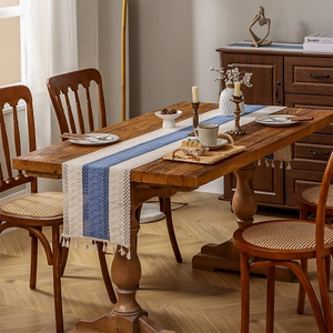Bohemian knit table runner with blue and beige color blocking and white tassels