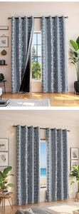 Detail of blue blackout curtain with floral patterns, white tassels, and black coating