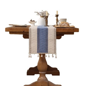 Bohemian woven table runner with beige and grey-blue stitching and tassel fringe details