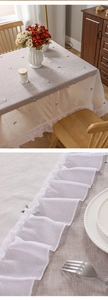 Close-up of cat embroidery and ruffled edge on minimalist linen tablecloth fabric