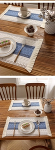Detail of woven table runner showing blue and beige stitching with delicate tassels