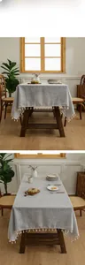 Detailed view of grey linen texture tablecloth with white decorative tassel trim
