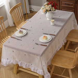 Minimalist cat embroidery tablecloth with ruffled lace edges in warm light setting