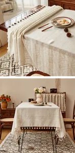 Close-up of cream linen tablecloth texture with elegant striped pattern and white tassels