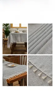 Detailed view of grey linen tablecloth with elegant cream cotton tassels on wooden table