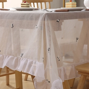 Elegant white ruffled tablecloth with minimalist black embroidery for dining tables