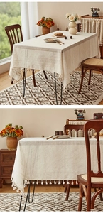 Close-up of beige linen tablecloth with rustic stripes and tassel fringe details