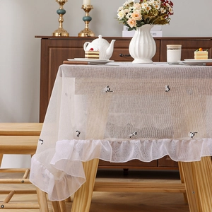 Modern cat embroidery tablecloth with elegant ruffled edges on a wooden table
