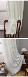 Detail of cream white lace curtain with delicate floral patterns and hollow stripes