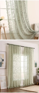 Détail du rideau en dentelle vert matcha avec broderie florale et bordures festonnées