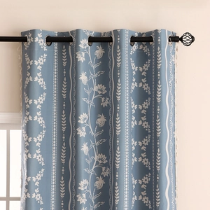 Blue blackout curtains with white floral vine prints and elegant silver grommets
