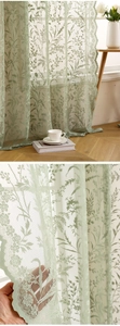 Détail du rideau en dentelle vert clair avec motifs floraux et bords ondulés