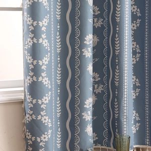 Blackout curtain in hazy blue with floral patterns and white decorative tassels