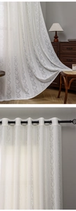 Detail of cream lace curtain with floral embroidery and black metal grommets for living room