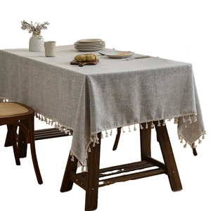 Minimalist grey bamboo linen tablecloth with elegant fringe tassels on a wooden table