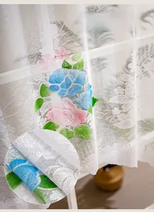 Close-up of white lace kitchen curtain with pink and blue 3D floral embroidery