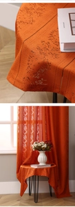 Detailed macro view of orange boho lace curtain with hollow-out floral crochet patterns